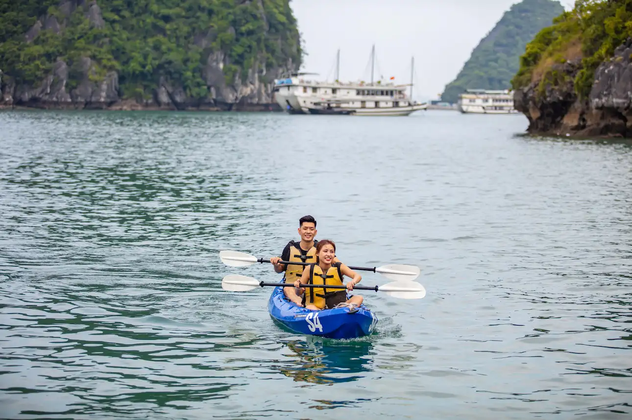 Du khách chèo thuyền kayak trên Vịnh Hạ Long giữa cảnh biển xanh và núi đá vôi hùng vĩ